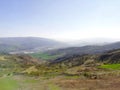 Mountain panorama in the early spring when nature awakens and where it is seen green meadows and trees and in the distance in the