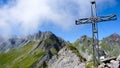 Mountain panorama with a gorgeous view of the Swiss Alps and valleys and a metal summit cross Royalty Free Stock Photo