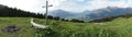 Mountain panorama with a gorgeous view of the Swiss Alps and Valleys and a summit cross Royalty Free Stock Photo