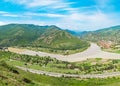 Mountain panorama with green field and blue sky. Royalty Free Stock Photo