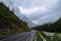 Mountain path leading towards the peak on the ridge with heavy clouds and the fog Royalty Free Stock Photo