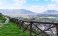 Mountain path with a wooden fence on a blue sky background. The Italian Apennines. Royalty Free Stock Photo