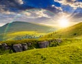 Mountain peak behind hillside with boulders at sunset Royalty Free Stock Photo