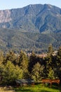 Mountain peak in bright sunlight. Wooden shelters in the foreground