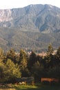 Mountain peak in bright sunlight. Wooden shelters in the foreground