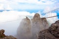 Mountain peak in the clouds with a suspension bridge. stairway to Heaven