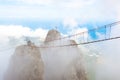 Mountain peak in the clouds with a suspension bridge. stairway to Heaven Royalty Free Stock Photo