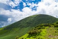 Mountain peak with green grass on hills and blue sky Royalty Free Stock Photo