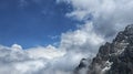 Mountain peak among heavy, massive clouds. Shot of Talgar peak. Snow-covered cliffs towering above the skies.