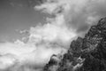 Mountain peak among massive, heavy clouds. Snow-covered cliffs towering above the skies. Shot of Talgar peak.