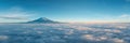 Mountain peak rising above a blanket of clouds at dawn Royalty Free Stock Photo