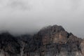 Mountain peak shrouded in thick clouds. The rocky surface is partially visible, creating a dramatic and mysterious atmosphere. Royalty Free Stock Photo