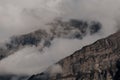 Mountain peak shrouded in thick clouds. The rocky surface is partially visible, creating a dramatic and mysterious atmosphere. Royalty Free Stock Photo