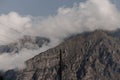 Mountain peak shrouded in thick clouds. The rocky surface is partially visible, creating a dramatic and mysterious atmosphere. Royalty Free Stock Photo
