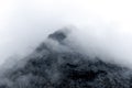 Mountain peak shrouded in thick clouds. The rocky surface is partially visible, creating a dramatic and mysterious atmosphere. Royalty Free Stock Photo