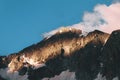 Mountain peak sunset landscape with gloomy dramatic mainly cloudy sky and orange and red sun beams Royalty Free Stock Photo