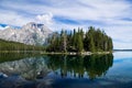 Mountain peak and tree-covered island reflected in an alpine lake Royalty Free Stock Photo