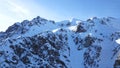 Mountain peaks covered with snow. Blue sky with light white clouds. Royalty Free Stock Photo