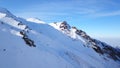 Mountain peaks covered with snow. Blue sky with light white clouds. Royalty Free Stock Photo