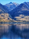 Mountain peaks of the Southern Alps reflecting in the waters of Lake Wanaka on the South Island of New Zealand