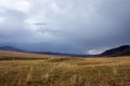 Mountain plateau with ancient mound and cloudy blue sky on background. Rural scenery. Summer nature landscape.