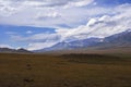 Mountain plateau with ancient mound and cloudy blue sky on background. Rural scenery. Summer nature landscape.