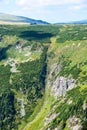 Mountain plateau falling down to a deep valley with a waterfall Royalty Free Stock Photo