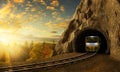 Mountain railroad with train in tunnel in rock above landscape.