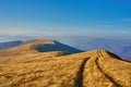 Mountain range with a dirt road among withered grass Royalty Free Stock Photo