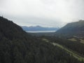 Mountain Range with Forests and Stream. Lush temperate rainforest in alaska with clouds and sun