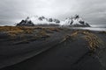 Mountain range in front of black sand dunes Royalty Free Stock Photo