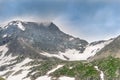 Mountain range with glaciers on slope under gloomy sky. Rainy gray clouds over snowy cliffs Royalty Free Stock Photo