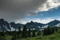 Mountain range with glaciers on slope under gloomy sky. Rainy gray clouds over snowy cliffs. Planning climb to top Royalty Free Stock Photo