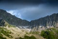 Mountain range with glaciers on slope under gloomy sky. Rainy gray clouds over snowy cliffs. Planning climb to top Royalty Free Stock Photo