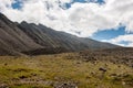 Mountain range and mountainside with stones and green grass. Royalty Free Stock Photo