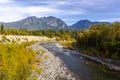 A mountain range towering over an autumn river landscape Royalty Free Stock Photo