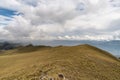 a mountain range with yellow grass and cloudy sky Royalty Free Stock Photo