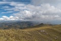 a mountain range with yellow grass and cloudy sky Royalty Free Stock Photo