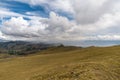a mountain range with yellow grass and cloudy sky Royalty Free Stock Photo