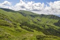 Mountain ranges with forested slopes and highland grassy valley. Landscape of Chornohora ridge, Carpthians Royalty Free Stock Photo