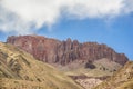 A mountain of red limestone in the middle of other yellow ones