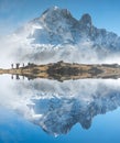 Mountain reflected in the Alps with some people hiking up