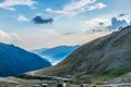 Mountain rescue house at the top of the mountain with cars passing on curvy road at the bottom and foggy forest covered mountains Royalty Free Stock Photo