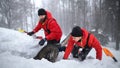 Happy mountain rescue service with dog on operation outdoors in winter in forest, digging snow. Royalty Free Stock Photo