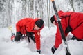 Mountain rescue service on operation outdoors in winter in forest, digging snow with shovels. Royalty Free Stock Photo