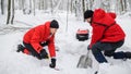 Mountain rescue service on operation outdoors in winter in forest, digging snow with shovels. Royalty Free Stock Photo