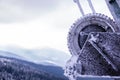 The mountain resort is a snow-covered gear of a boom lift, the mountains and a steep-colored gloomy sky in the background