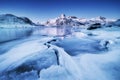 Mountain ridge and ice on the frozen lake surface. Natural landscape on the Lofoten islands, Norway.