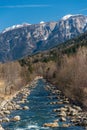 Noce River surrounded by snow-capped mountains Italian Alps Dolomities