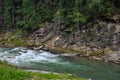 Mountain river in the Carpathian mountains Ukraine with a rock in the background and a dense forest.